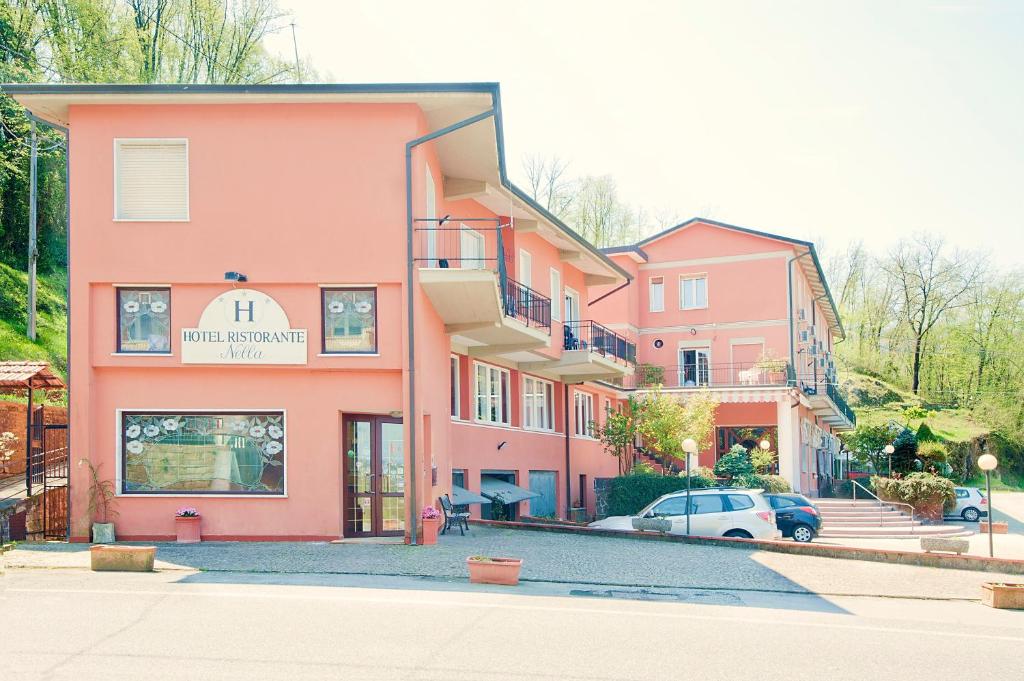 斯培西亚内拉酒店的一座粉红色的建筑,前面有一辆汽车