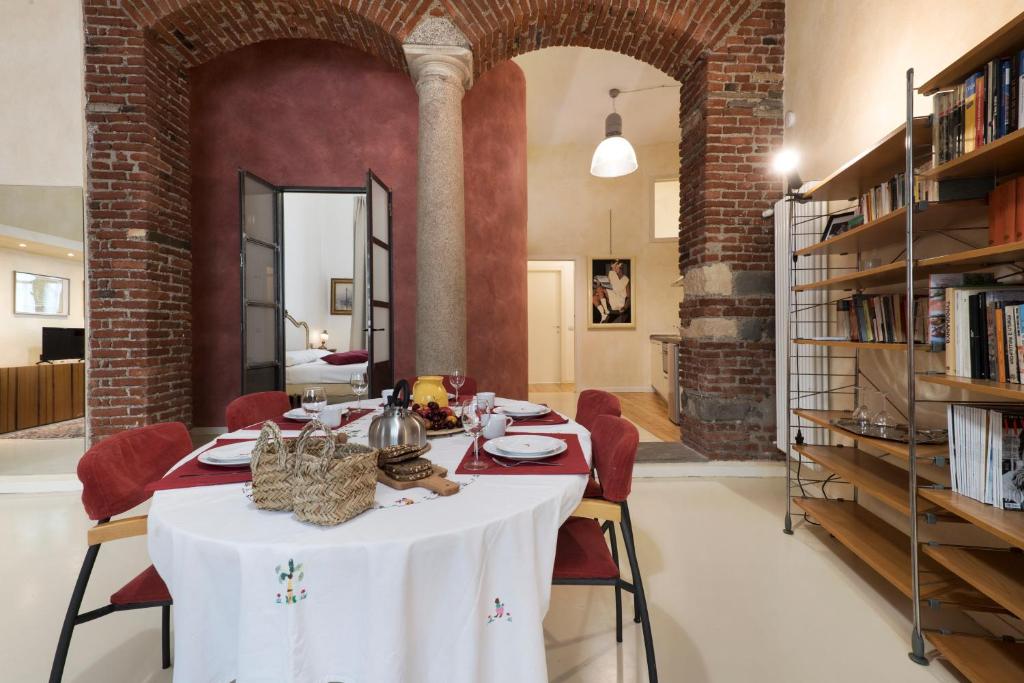 米兰Luxury Apartment Fioravanti的一间带桌子和书架的用餐室