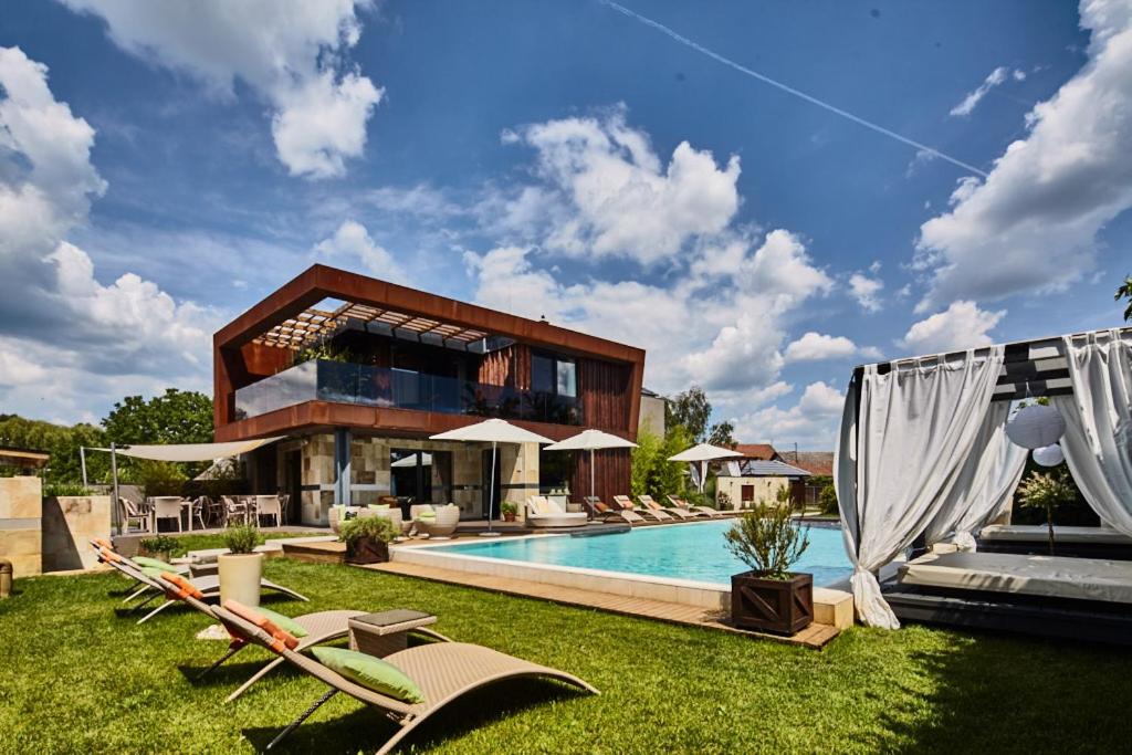 奥巴曹洛克布提克设计客房的一座带游泳池和一些草坪椅的房屋