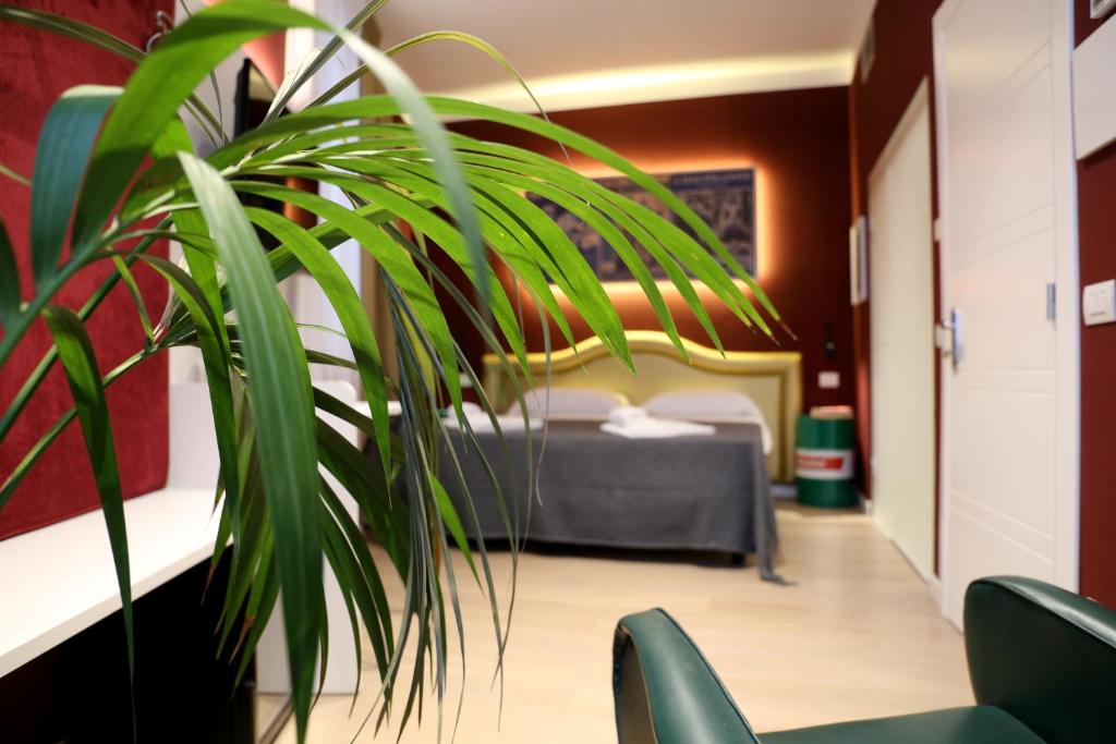 维罗纳OFFICINA TESINI Guest Rooms Verona的一间卧室配有一张床和盆栽植物