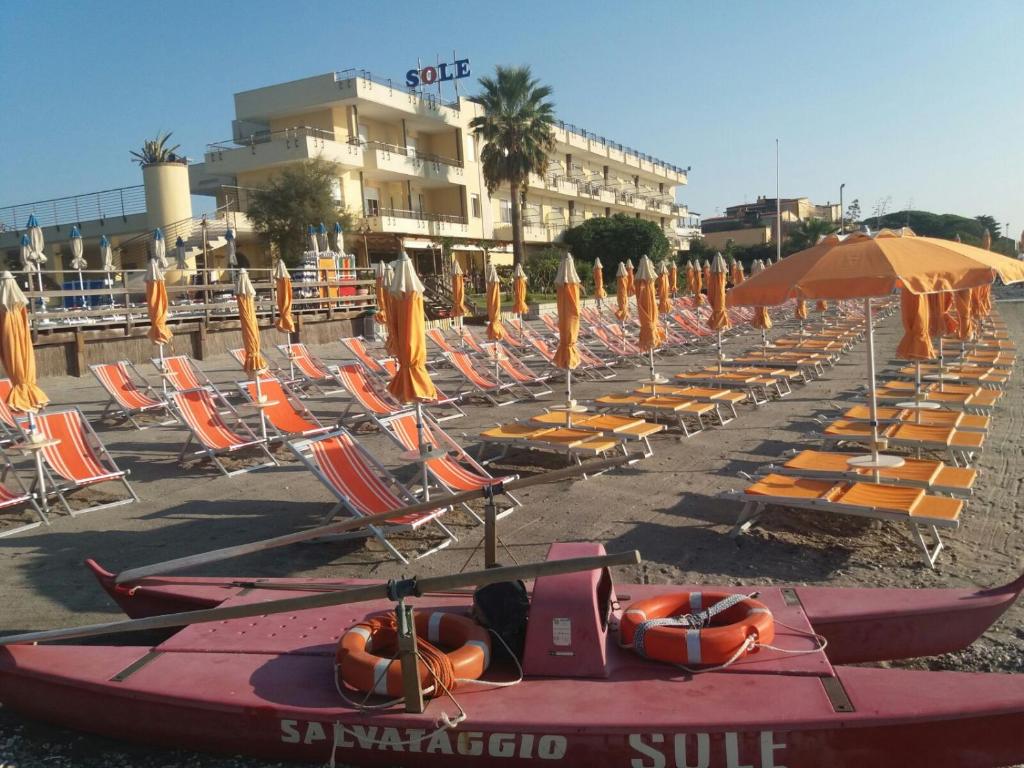 阿尔本加索尔酒店的海滩上的一排躺椅和遮阳伞
