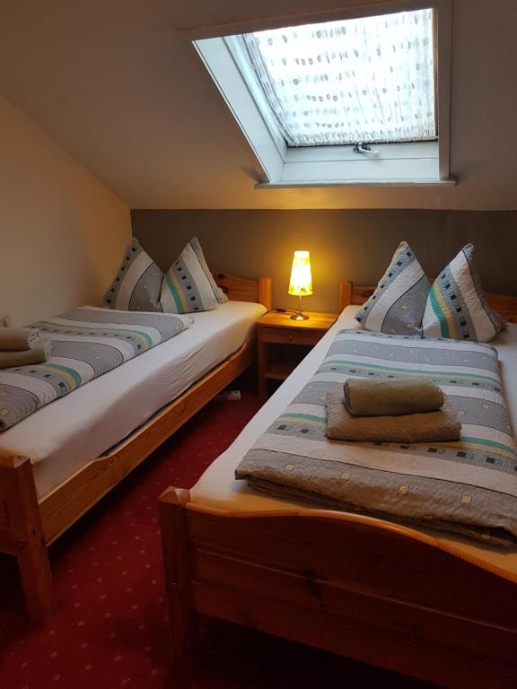 奥斯特菲尔登斯切恩莱因哈特酒店的带窗户的客房内的两张床