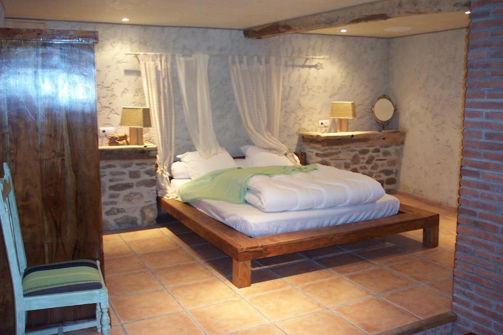 普拉德莫洛拉普雷斯特卡萨尔酒店的一间卧室配有带窗帘的床和椅子