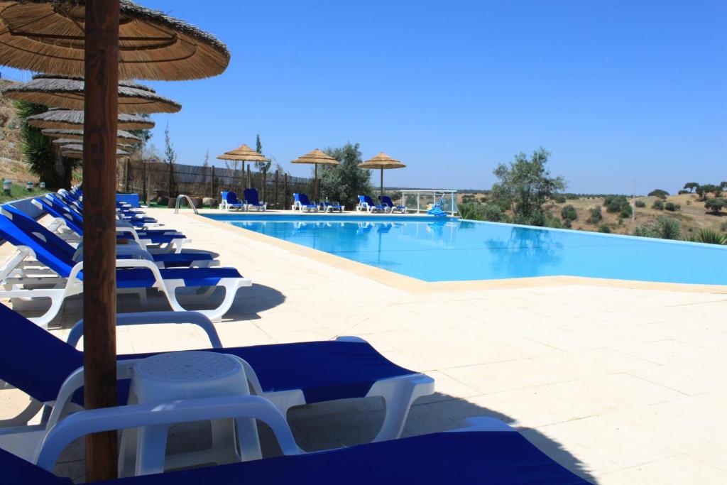 奥迪韦拉什Hotel O Gato - Edificio Standard的一个带蓝白色椅子和遮阳伞的游泳池