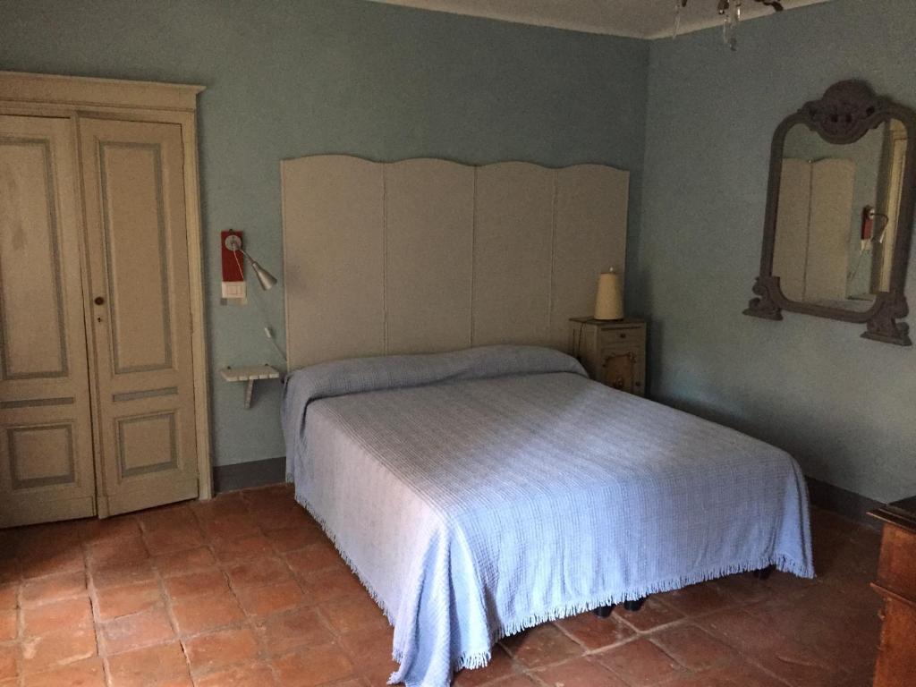 MagnanoAppartamenti a Magnano的卧室配有一张床,墙上设有镜子