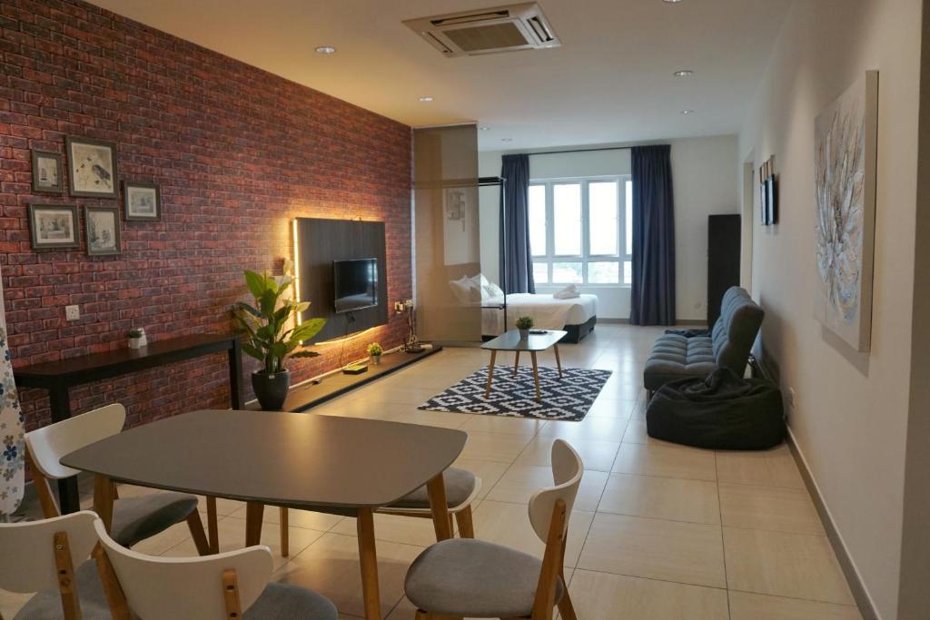 怡保PM Octagon Ipoh Suites & Apartment 3的客厅配有桌子和砖墙