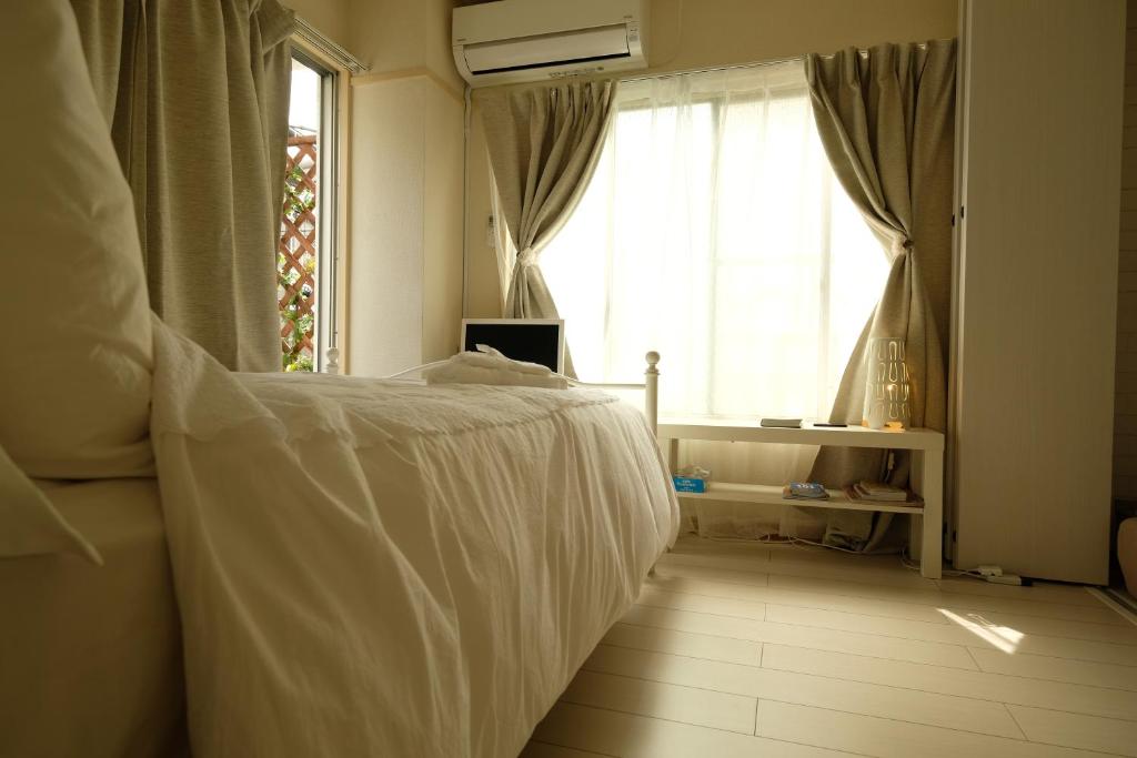 东京COCO Nakameguro 201的卧室配有白色的床和窗户。