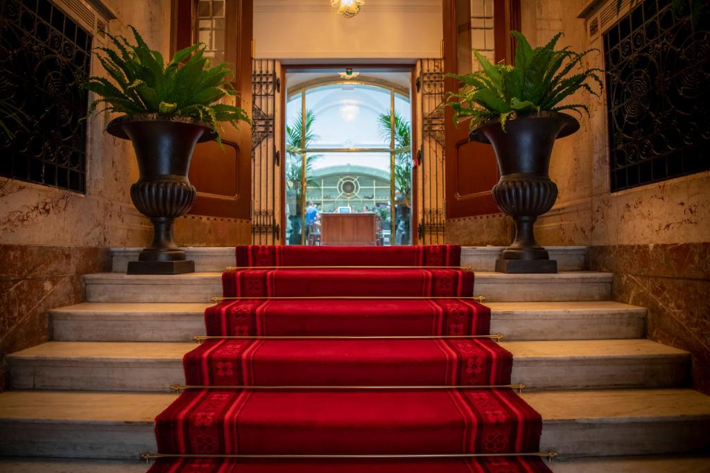 斯德哥尔摩Bank Hotel, a Member of Small Luxury Hotels的一座带花瓶的建筑里一套红色的楼梯