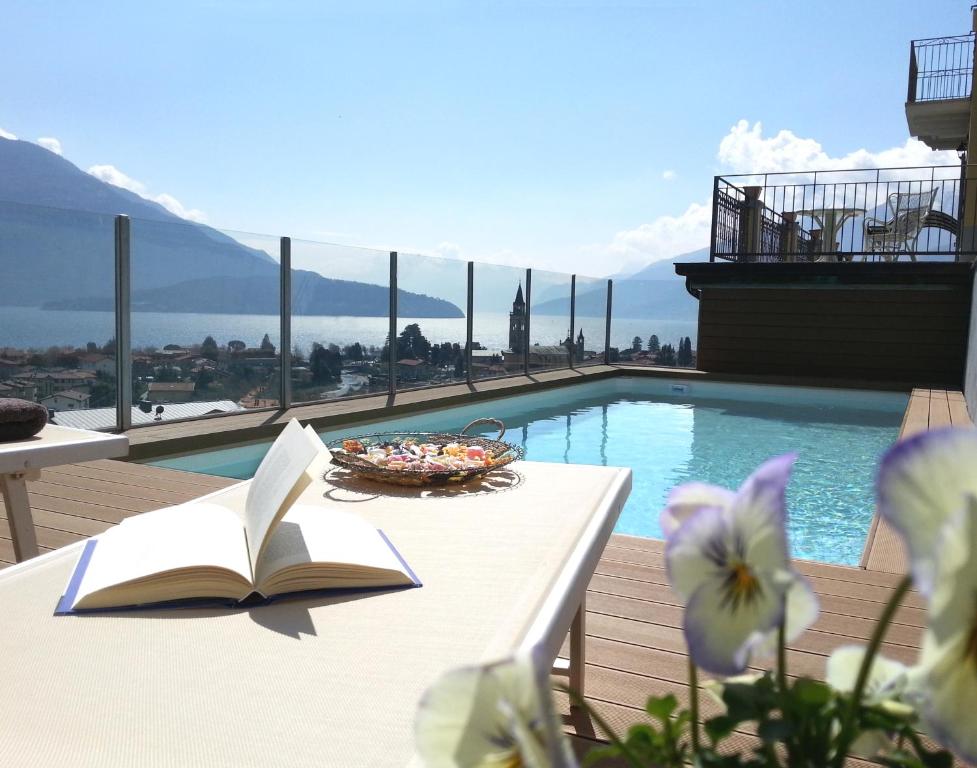韦尔卡纳Villa Perla del Lago的坐在游泳池旁桌子上的书