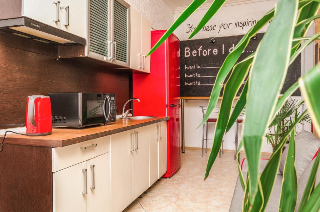 基辅Хостел 17的厨房配有白色橱柜和红色墙壁