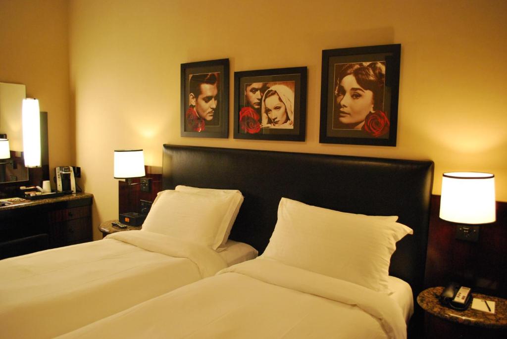 纽约华盛顿广场酒店的两张位于酒店客房的床,墙上挂有照片