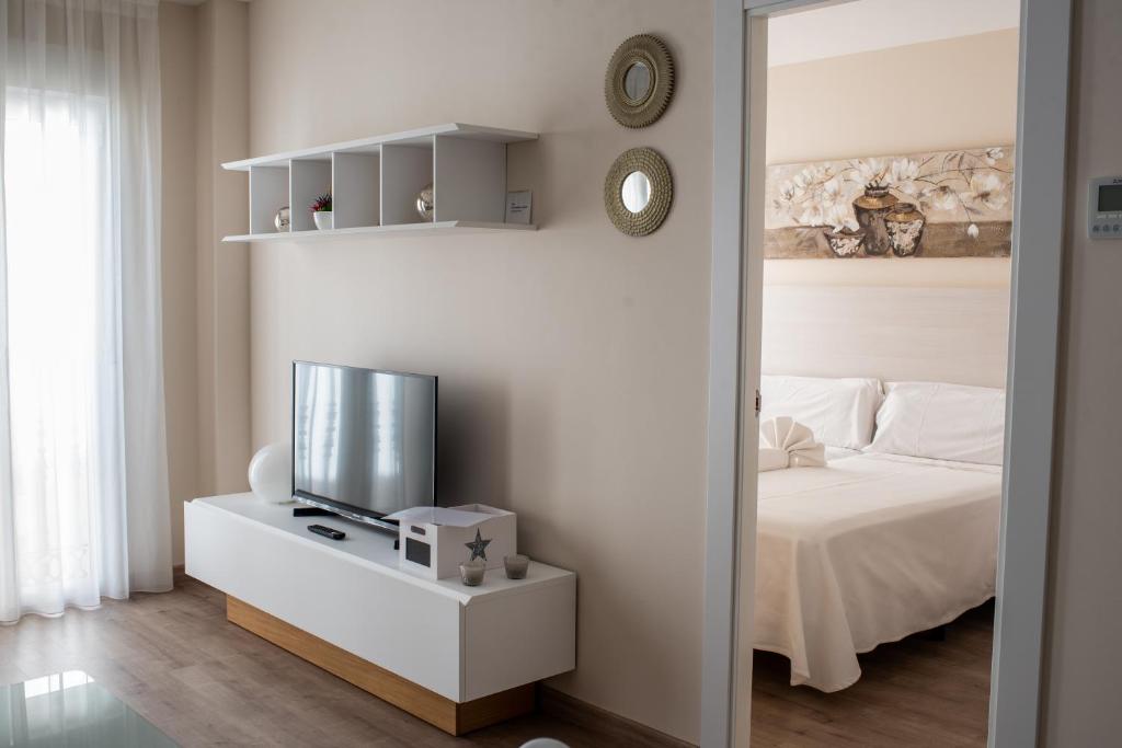 阿尔巴塞特玛索公寓的一间卧室配有一张床和一张桌子上的电视