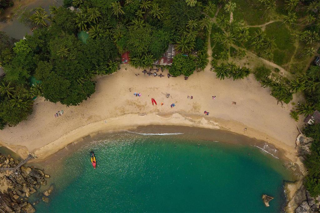 Than Sadet Beach麦喷清莱简易别墅酒店的海滩上的人在水中