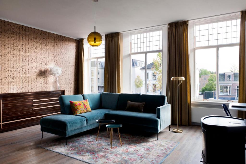 阿森Rooftop 52, City-Apartment的客厅设有蓝色的沙发和一些窗户。