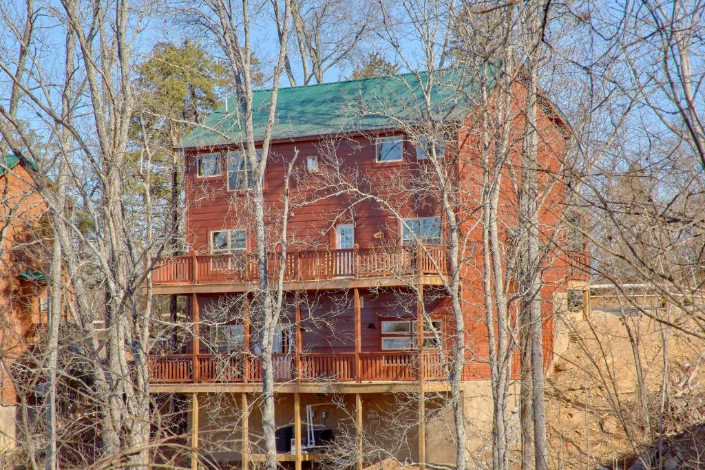 鸽子谷Alpine Pool Lodge的一座红色的大房子,树上有一个甲板