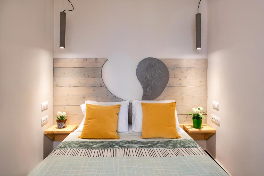 菲罗斯特法尼阿弗罗蒂特酒店的一间卧室配有一张带黄色枕头的床