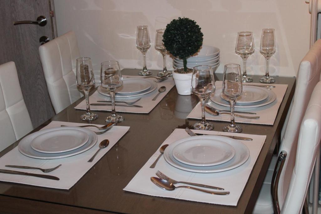 塞萨洛尼基Mesochoriou Apartment的一张桌子上放有盘子和酒杯