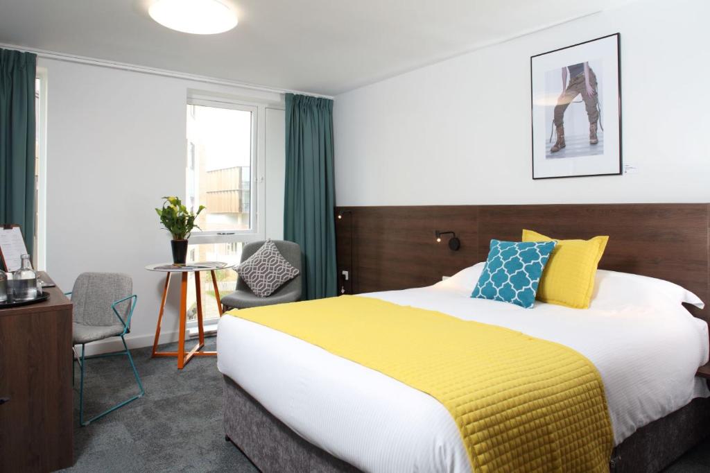 北安普敦Sunley Hotel的一间卧室配有一张带黄色毯子的大床