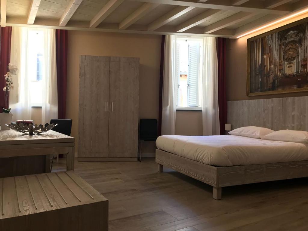 帕尔马Palazzo Domanto Apartments Parma的卧室配有一张床、一张书桌和窗户。
