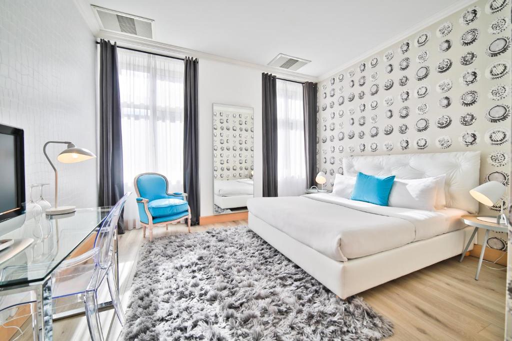布拉格星期五酒店 的卧室配有白色的床和蓝色椅子