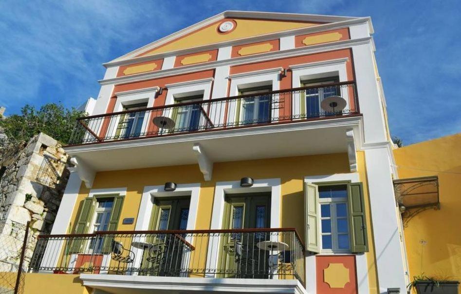 锡米西娅酒店的黄色和白色的建筑,设有阳台