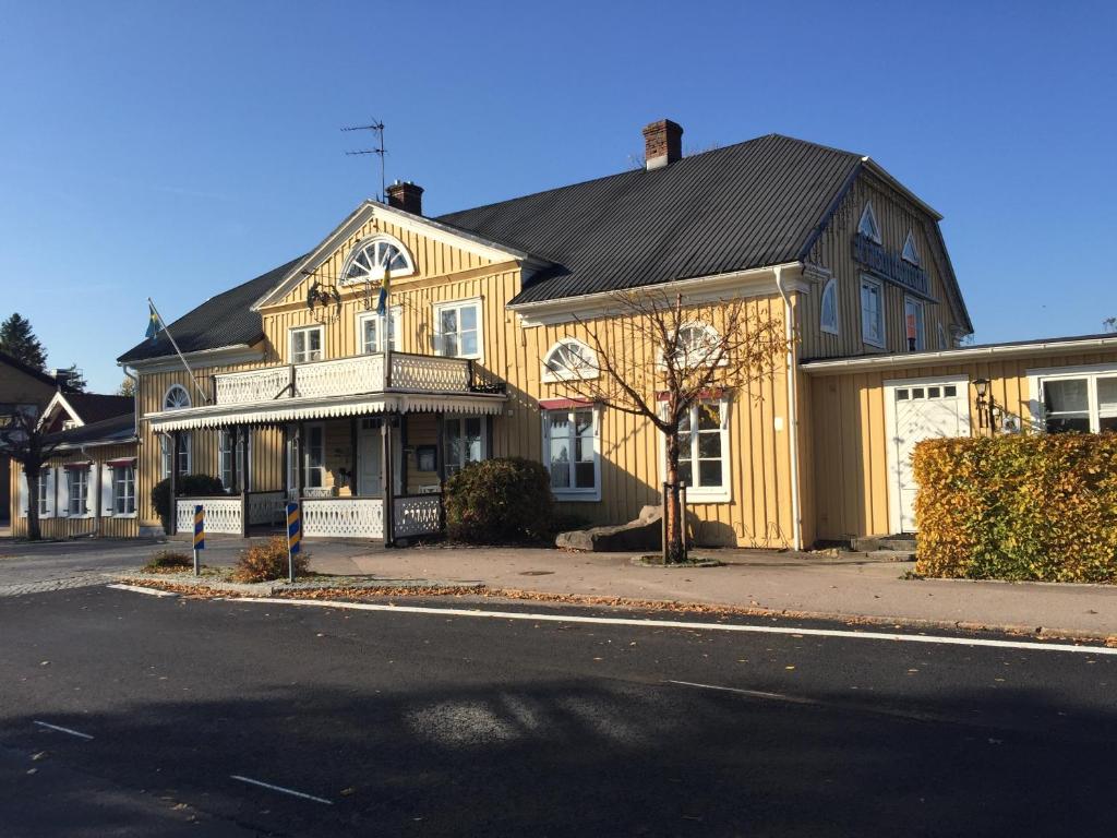 TorupTorups Gästgivaregård的街上有黑色屋顶的黄色房子