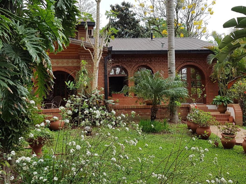 WandaWanda Apart Hotel Las Palmas的砖屋,花园中种植了盆栽植物