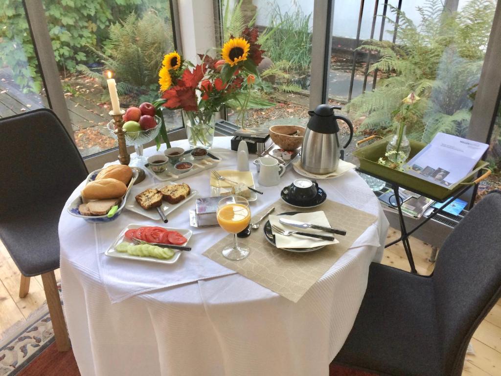 Marmagen艺术爱好者之家住宿加早餐旅馆的一张带食物和饮料的白色桌子