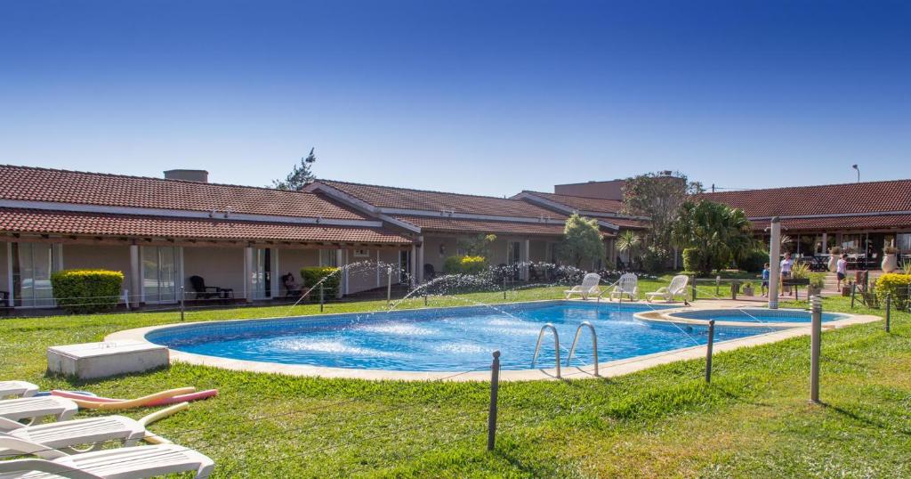 费德拉西翁瓦勒俱乐部铁尔玛鲁度假村的庭院内的游泳池,配有草坪椅