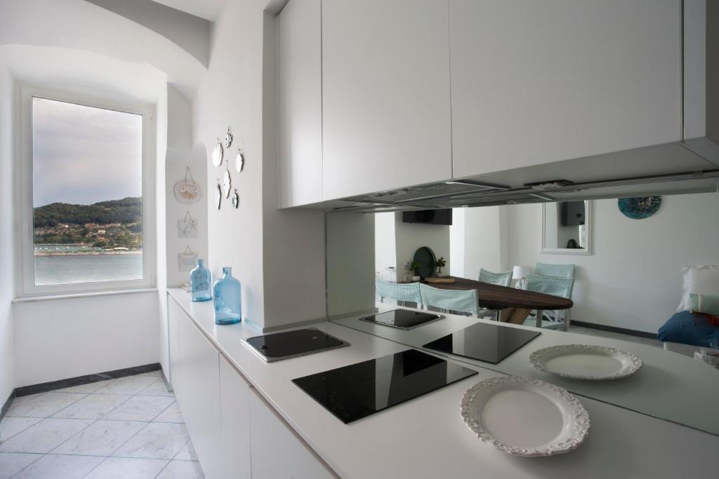 韦内雷港Vongola的厨房配有白色橱柜和台面