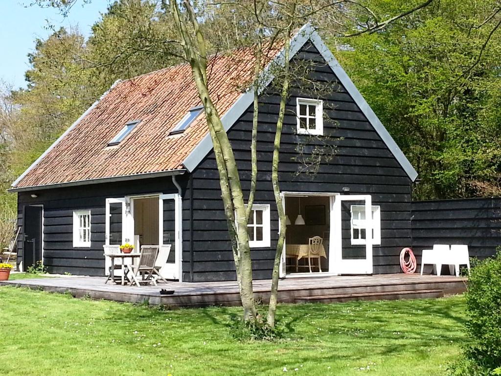 GoedereedeGastenverblijf Oostdijk的黑色房屋设有门廊和天井