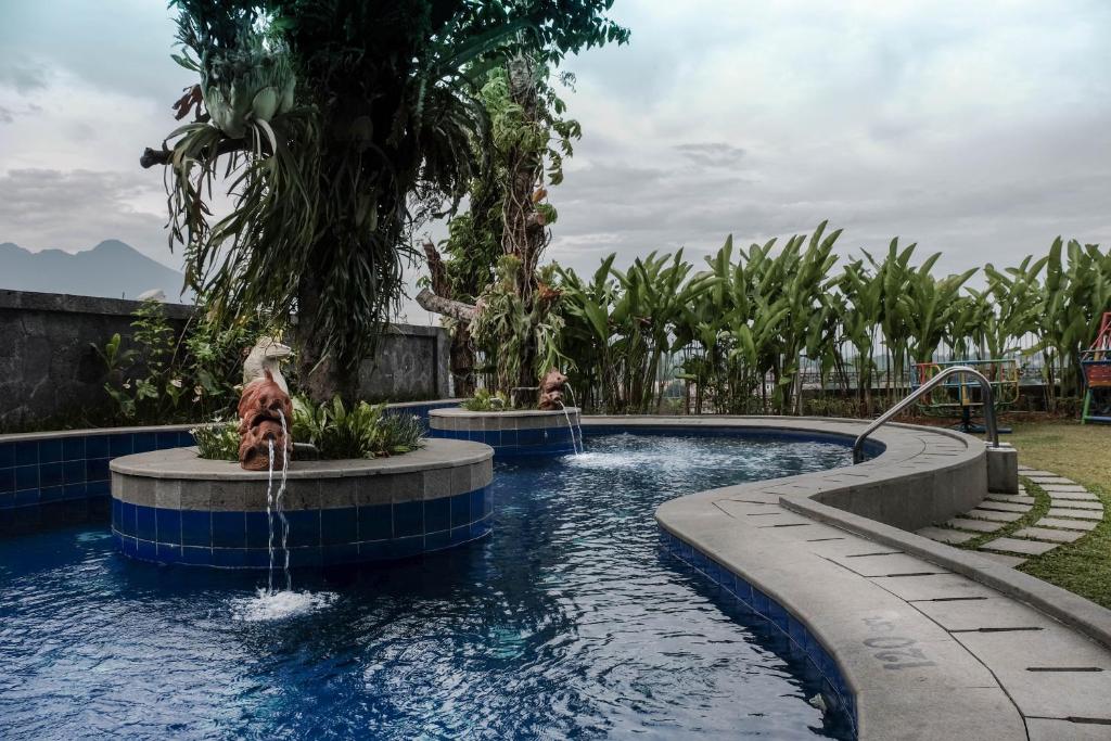茂物Onih Hotel的度假村内带两个喷泉的游泳池