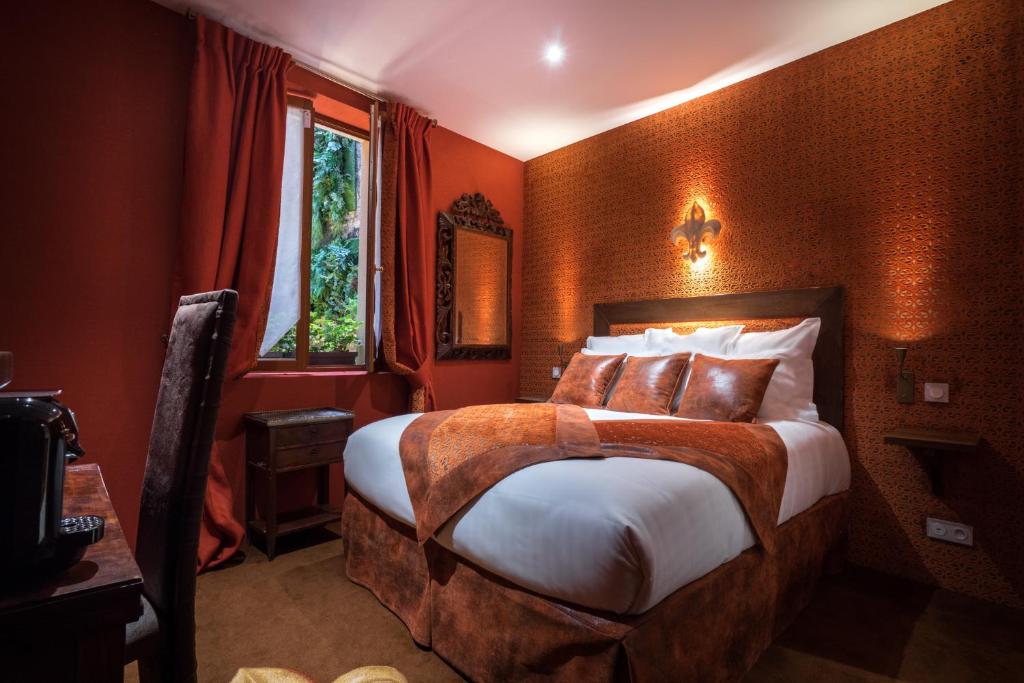 巴黎Le Temple De Jeanne的一间卧室配有一张带橙色墙壁的大床