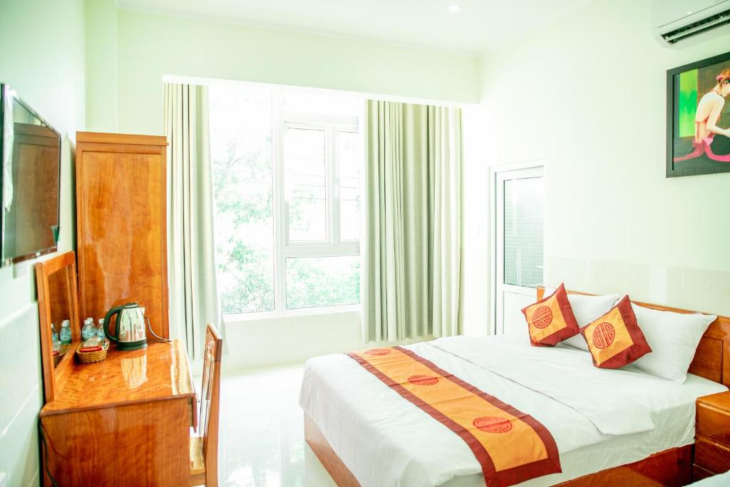潘郎Khách Sạn Anh Khoa的酒店客房设有床和窗户。