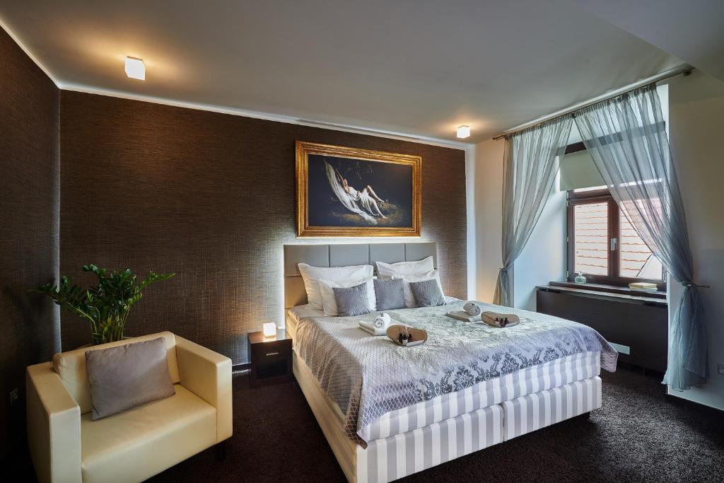 科希策克里索精品酒店的配有一张床和一把椅子的酒店客房