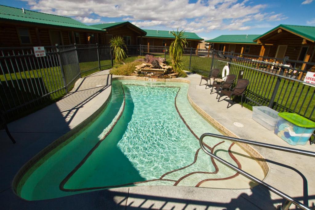 科迪科迪牛仔村酒店的一座房子旁的院子内的游泳池