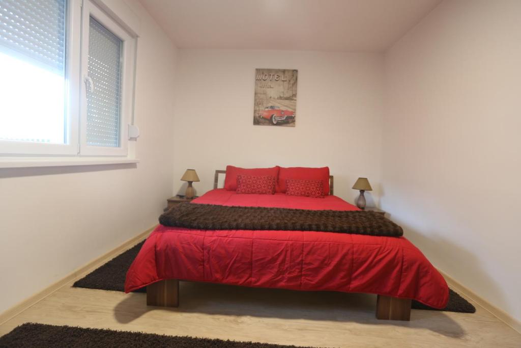萨拉热窝Seher的一间卧室配有红色的床和红色枕头