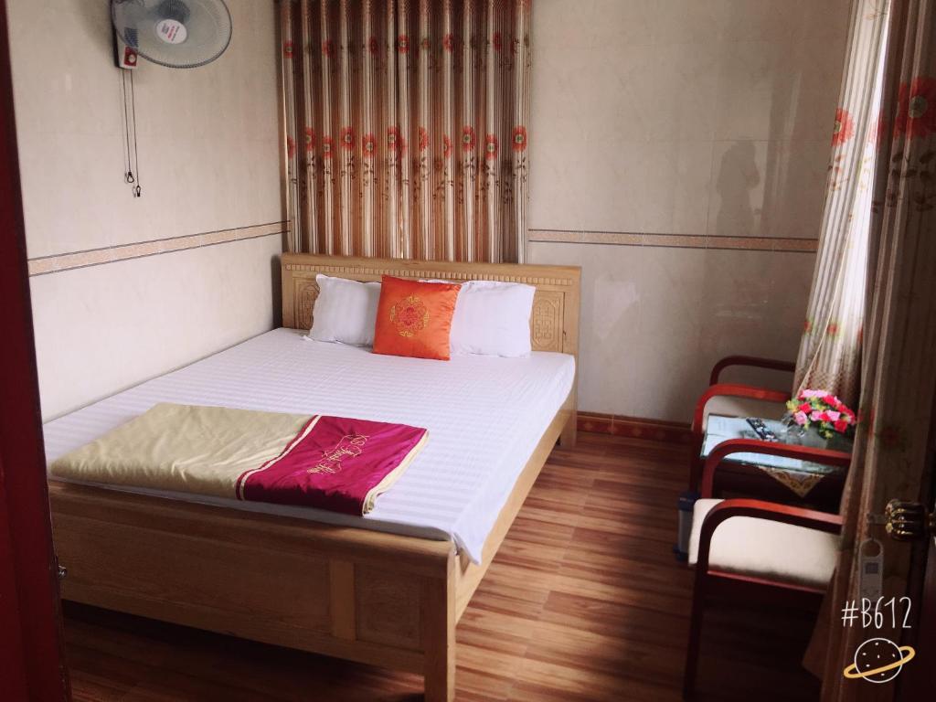 河静Thanh Binh Hotel的一间卧室配有带白色床单和橙色枕头的床。