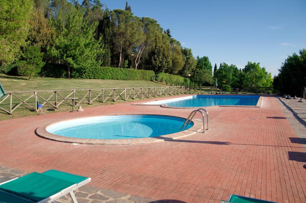 科尔恰诺Le Gorghe di Valmarino的砖砌庭院设有2个游泳池