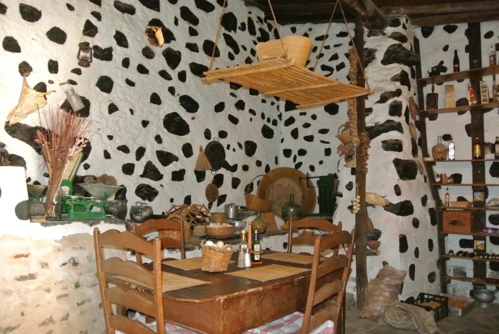 贝坦库里亚卡萨公主阿敏达酒店的一间设有桌子和牛印墙的用餐室