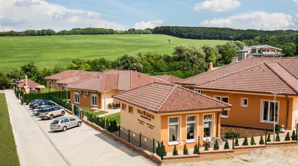 波达雅斯卡Villa Gracia Podhájska的车道上一排有汽车的房屋
