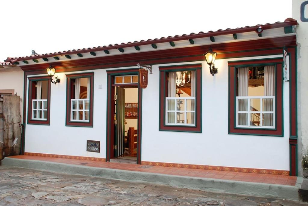 迪亚曼蒂纳Pousada Vila do Imperador的白色的建筑,设有窗户和门