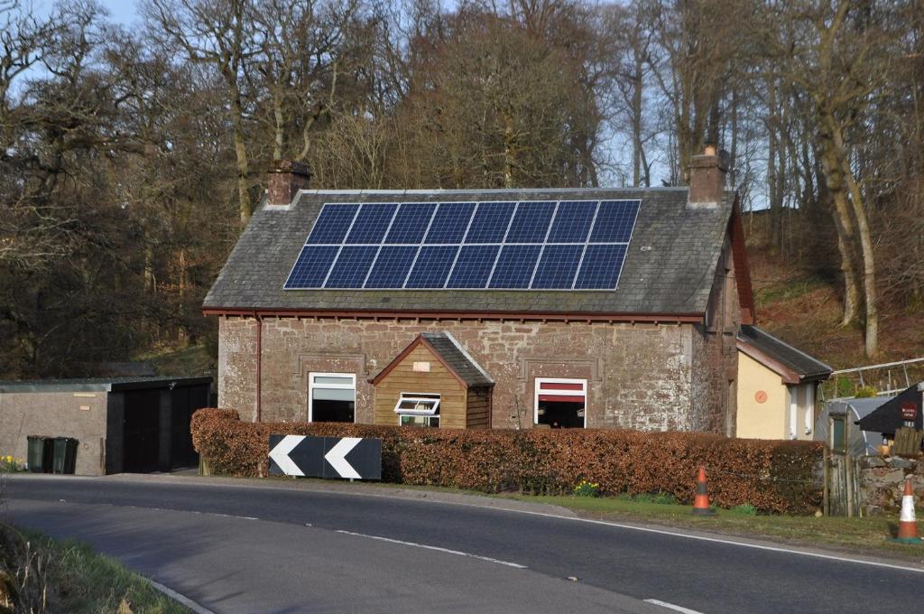 克里夫Bridgehill Cottage Bed & Breakfast的屋顶上设有太阳能电池板的房子