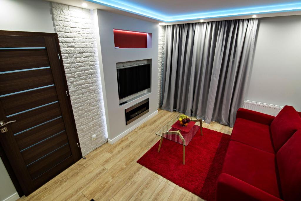 什切青JAB Apartments Panoramika Business & Family的客厅配有红色沙发和电视