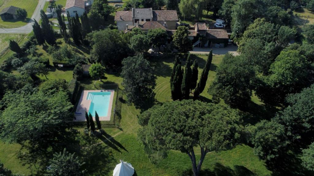 AzasVilla Toscane - Atelier d'Artistes et B&B à 20 mn de Toulouse的享有带游泳池和树木的房屋的空中景致