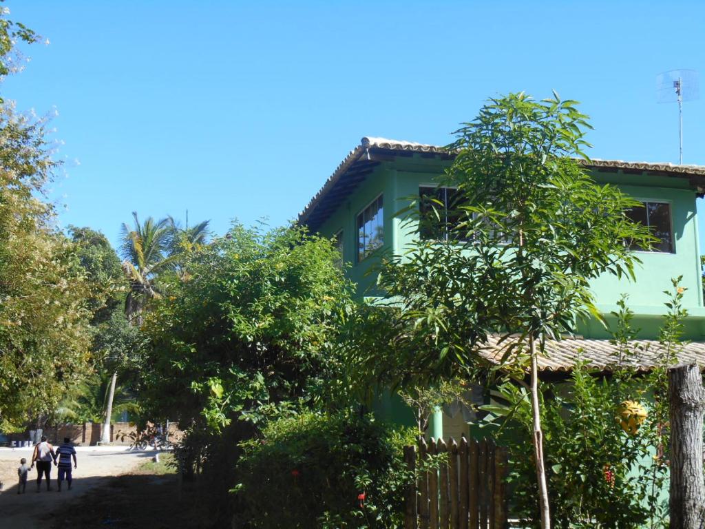 库穆鲁沙蒂巴Apartamento Cumuru的前面有棵树的绿色房子