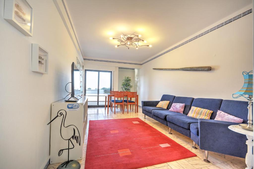 法鲁In Faro with Sea View的客厅配有蓝色的沙发和红色地毯。
