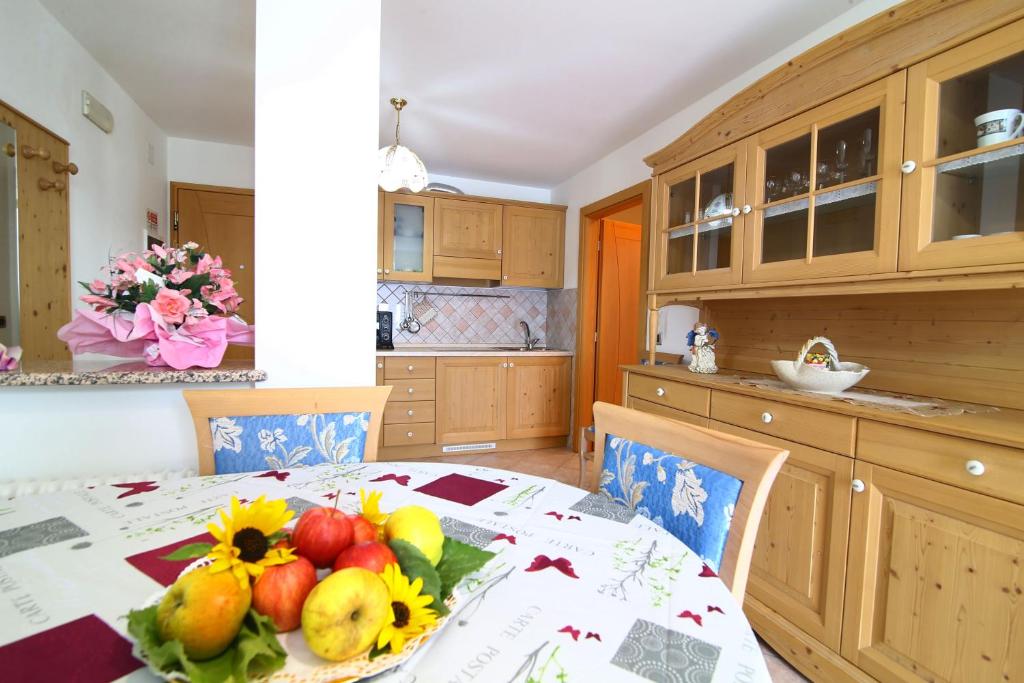 费德拉帕加内拉Paradise Apartments Paganella的厨房配有带水果的桌子
