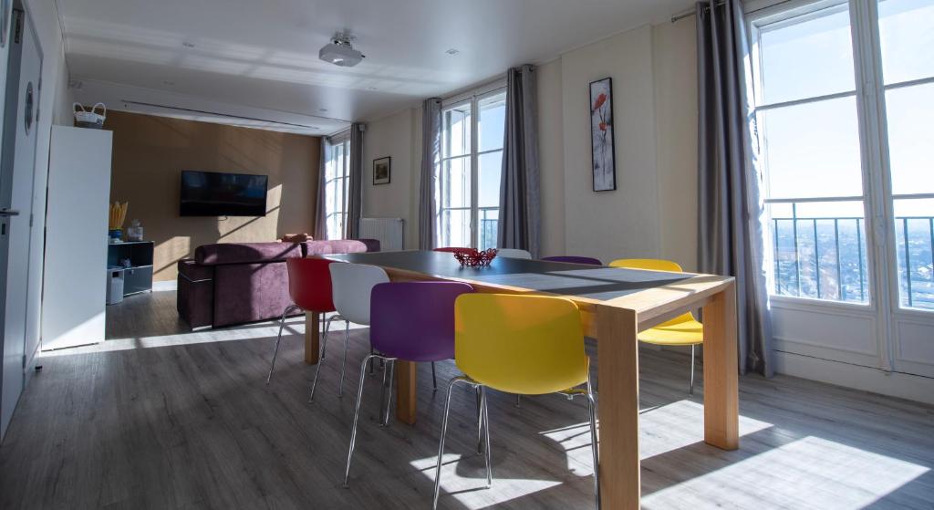 亚眠Le 360 TOUR PERRET 19eme PANORAMA 4 ETOILES的一间配备有桌子和五颜六色椅子的用餐室
