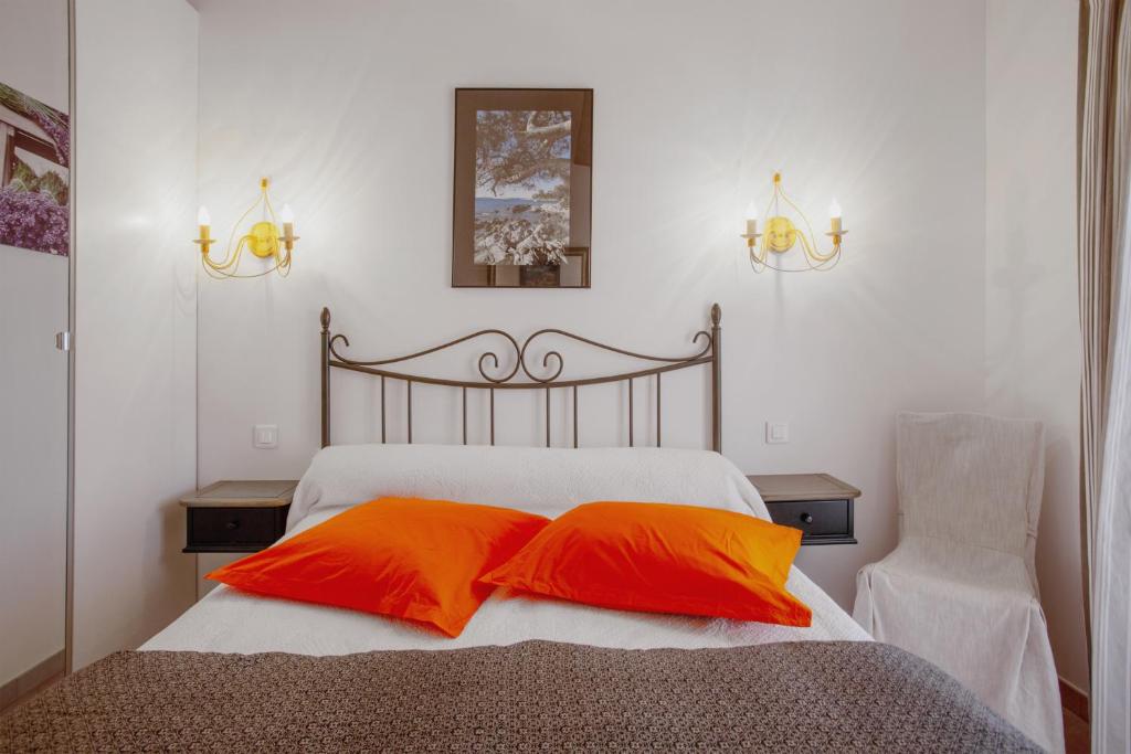 勒拉旺杜coustelline的一间卧室配有带两个橙色枕头的床